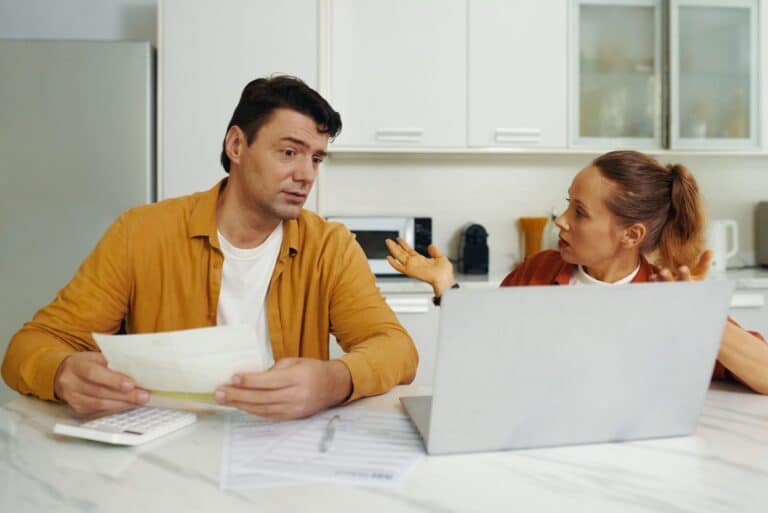 Couple discussing prenup modifications together at home with legal documents and laptop