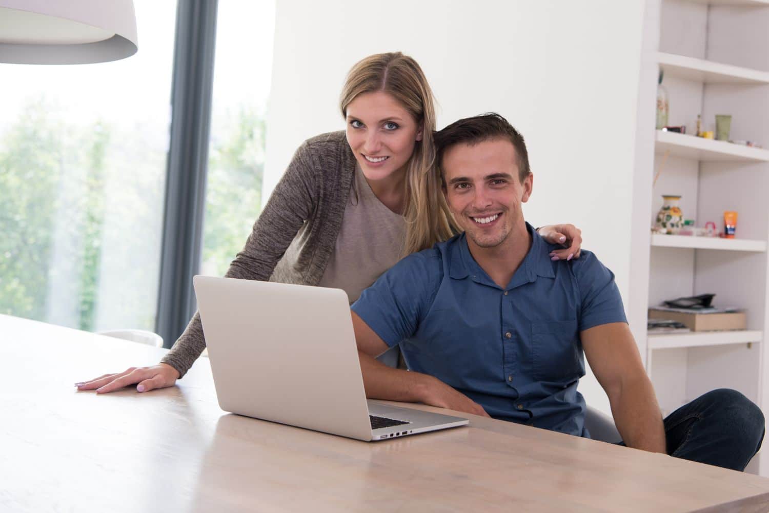 Young couple reviewing prenuptial agreement documents together at home with laptop - prenup guide 2025